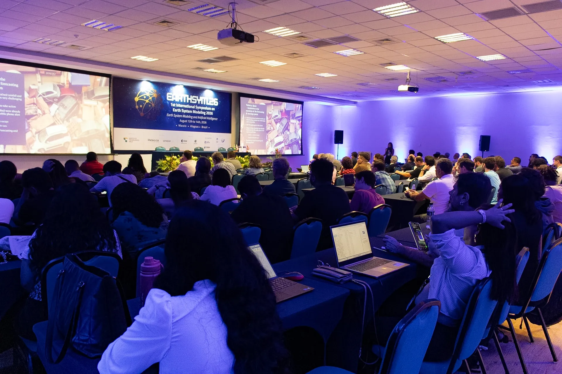 Plenária lotada no Centro de Eventos do Jatiúca, vista de trás da plateia, durante congresso internacional