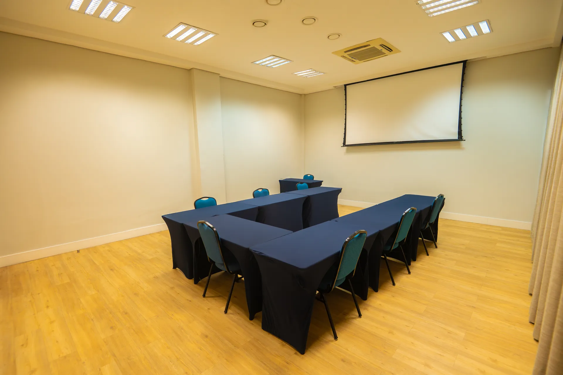 Salão Piaçabuçu montado em mesa em U, com a tela de projeção ao fundo