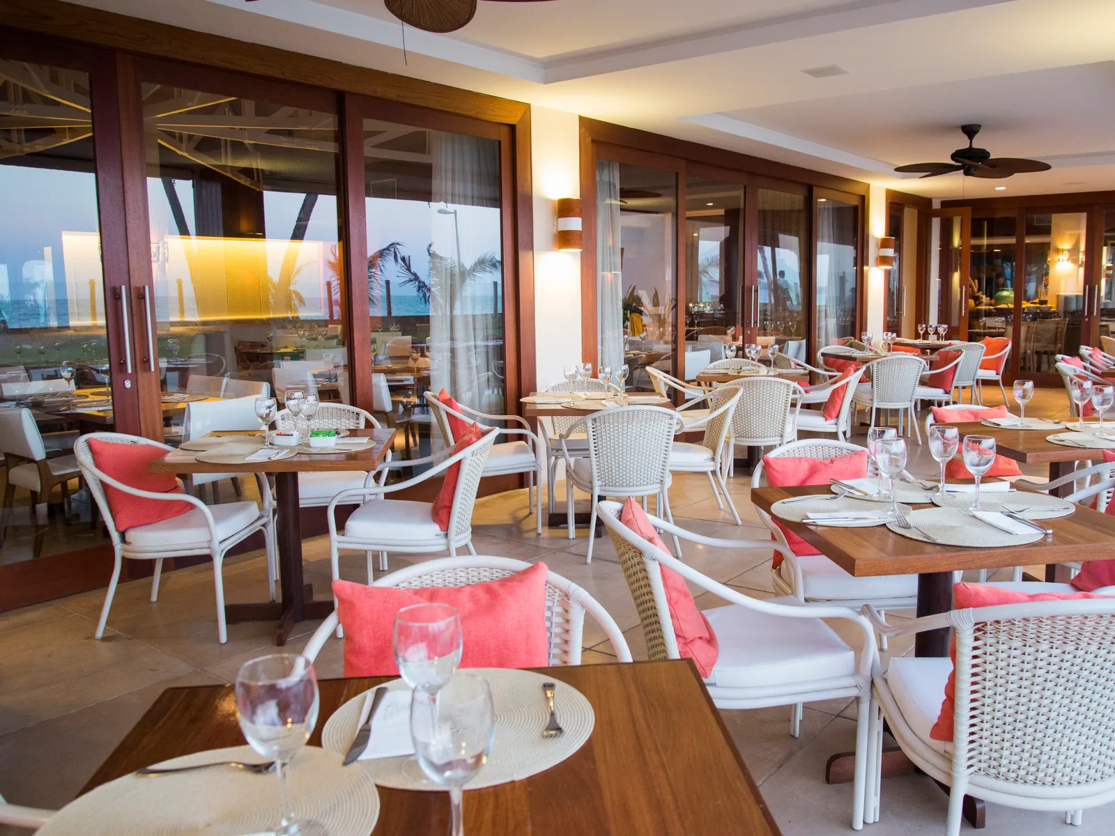 Salão do restaurante Canoas preparado para o jantar, com mesas postas e luz acolhedora
